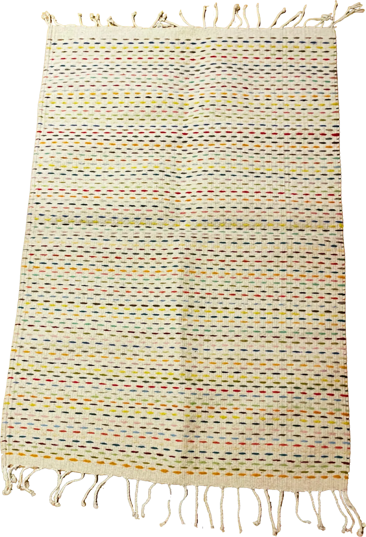 The Milpa rug seen from above: an ivory wool ground crossed by rows of small coloured dashes, with a hand-twisted fringe at each end.